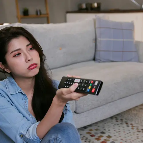 Woman holding TV remote